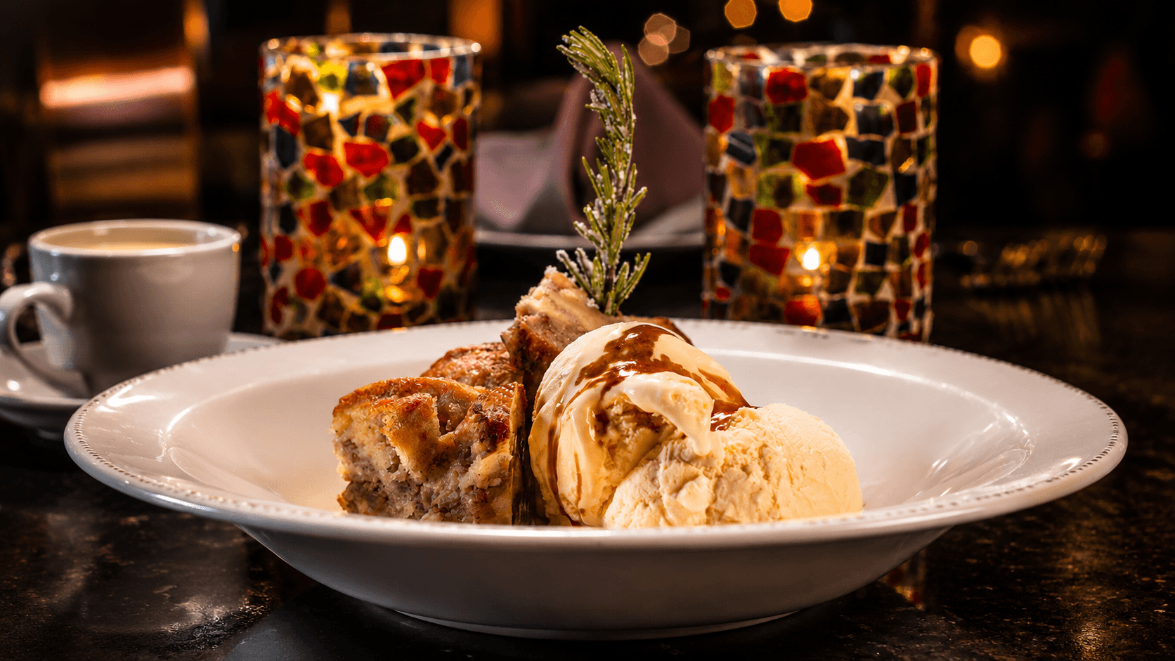 Warm bread pudding with vanilla ice cream, caramel drizzle, and a rosemary sprig in the cantina