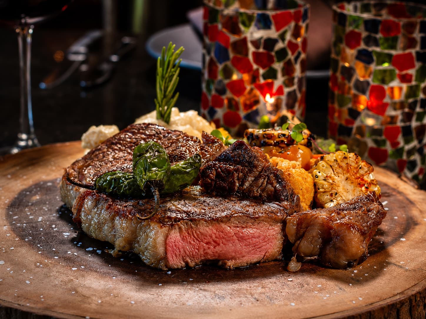 Grilled ribeye plated with shishitos and mashed potatoes